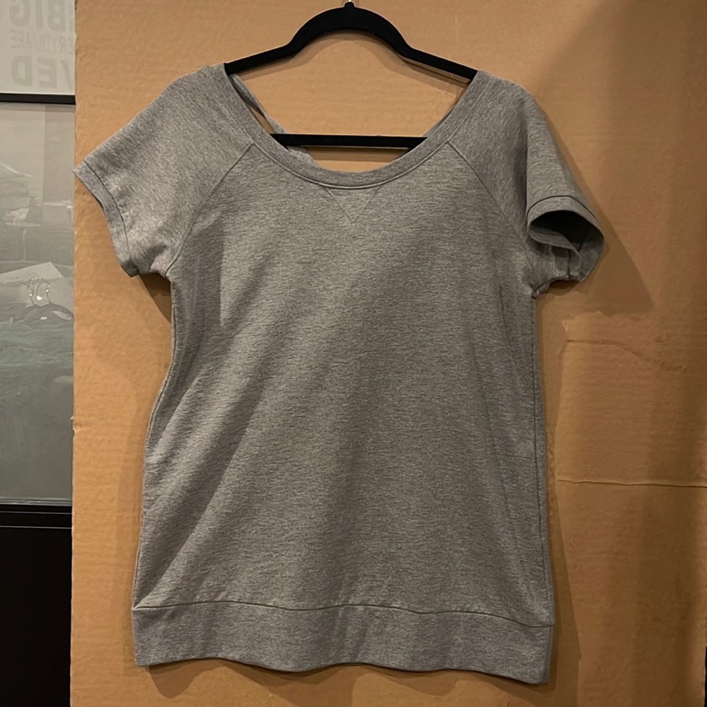 Nene leakes grey short sleeved sweatshirt with cross straps in the back.
